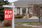 Home with "for rent" sign outside