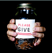 Hands holding jar with a "please give" sign on it